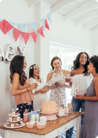 Pregnant woman and friend standing and talking at a celebration