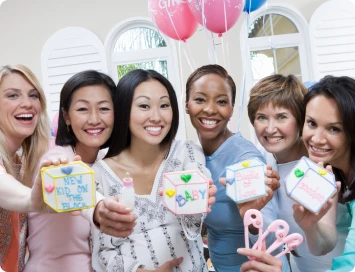 Group of women holding colourful blocks spelling "Baby"