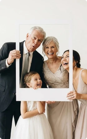 Older couple smiling playfully inside a photo booth frame
