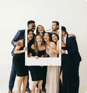 Wedding guests having fun and posing with a photo booth frame