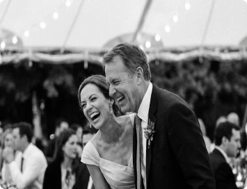 Smiling couple sitting on the floor looking at printed photo booth pictures